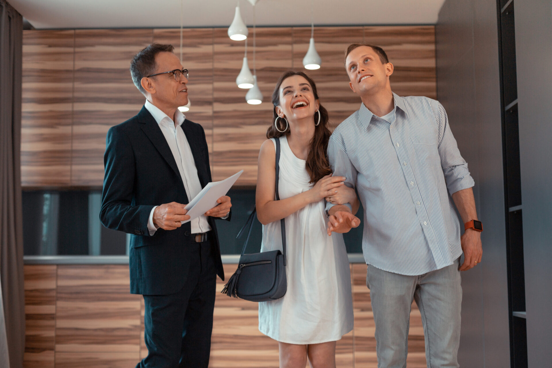 Wife feeling amazing while buying new apartment with husband while standing near realtor